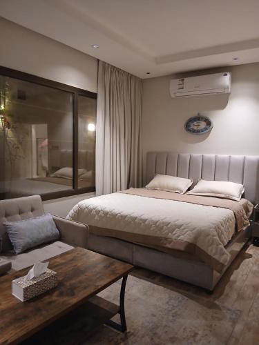 ein Schlafzimmer mit einem großen Bett und einer Couch in der Unterkunft دور ارضي كبير وواسع للضيافة والتحويل لحسابي بعد الوصول للمنزل in Riad