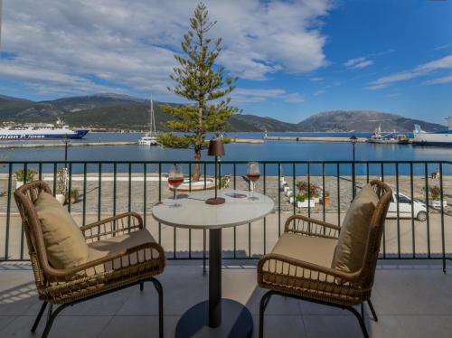 a table with two chairs and a tree on a balcony at Cavaliere Seafront House - Thalia in Sami