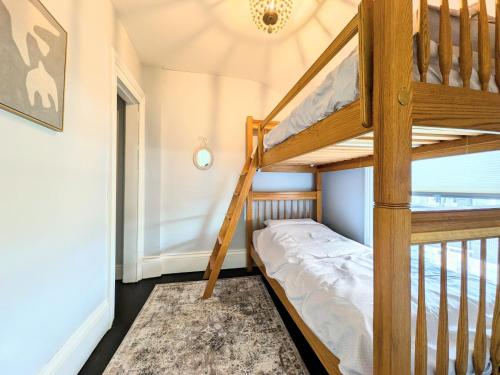 a bunk bed in a room with a ladder at Red Roof Guesthouse in Cobourg