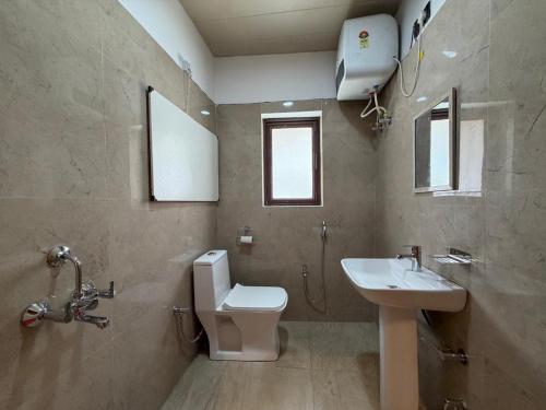 a bathroom with a toilet and a sink at The Juniper Ladakh Guest House in Kargil