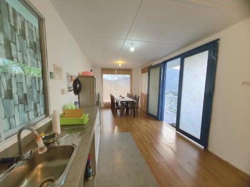 a kitchen with a sink and a table with chairs at D' Limbai Cottage in Ranau