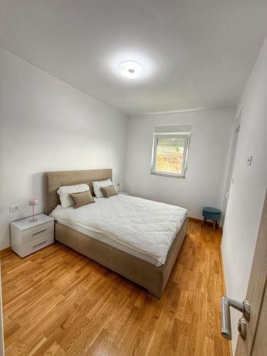 a bedroom with a large bed and a wooden floor at Maison Budva in Bečići
