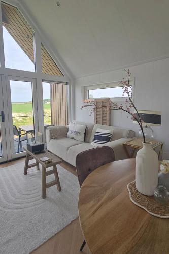 a living room with a couch and a table at Wad & Loft unieke paalwoning vlakbij de Waddenzee in Pietersbierum