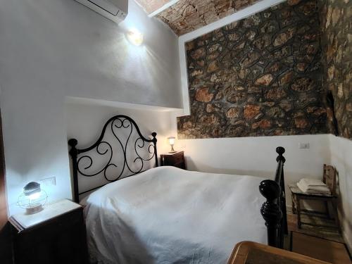 a bedroom with a bed and a stone wall at Pilarella Gallery trilocale vistamare in Porto Santo Stefano