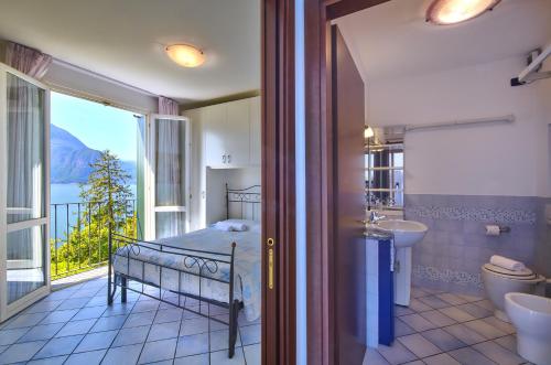 a bedroom with a bed and a balcony with a view at Bella Vista in Varenna