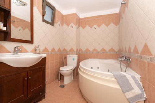 a bathroom with a sink and a tub and a toilet at Finiki Plaza in Methoni