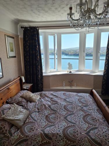 a bedroom with a large bed with a large window at Moon River in Goodwick