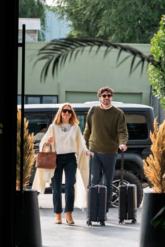 a man and a woman walking with their luggage at EHBoutique Experience in El Calafate