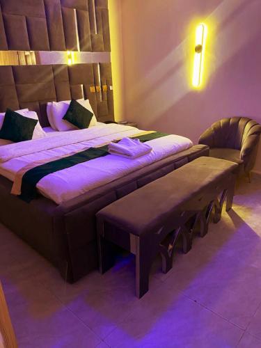 a bedroom with two beds with purple lighting at NH Norvits Hotel in Agbor