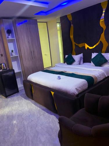 a hotel room with two beds and a couch at NH Norvits Hotel in Agbor