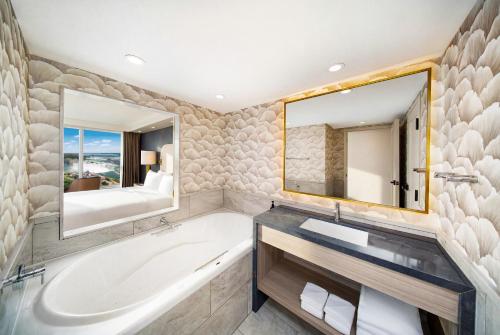a bathroom with a tub and a sink and a mirror at Hyatt Regency Niagara Falls Fallsview in Niagara Falls