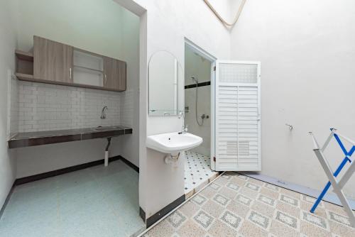 a white bathroom with a sink and a toilet at RedDoorz Plus at Orange Diponogoro Palangkaraya in Palangkaraya