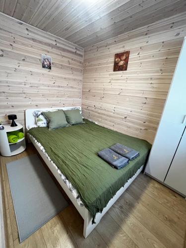 a bedroom with a bed in a wooden wall at Liepų namelis - Linden Shore in Miroslavas