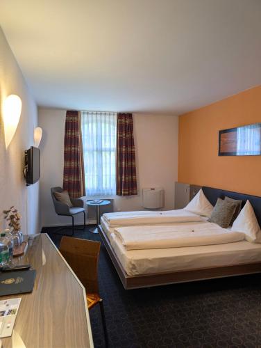 a hotel room with a large bed and a desk at Gasthaus Bären Kölliken in Kölliken
