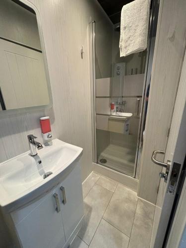 a white bathroom with a sink and a shower at Kings Boutique Hotel in Blackpool