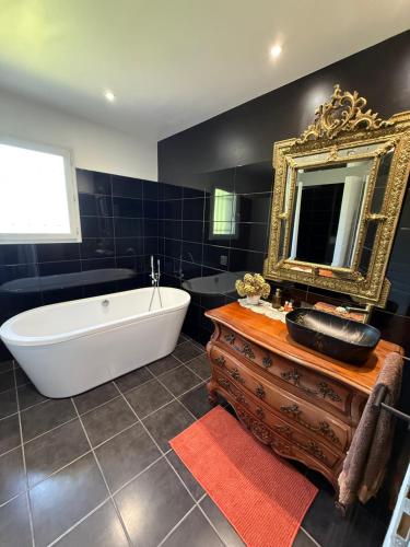a bathroom with a white tub and a mirror at La Maison d’Isabel in Montauban
