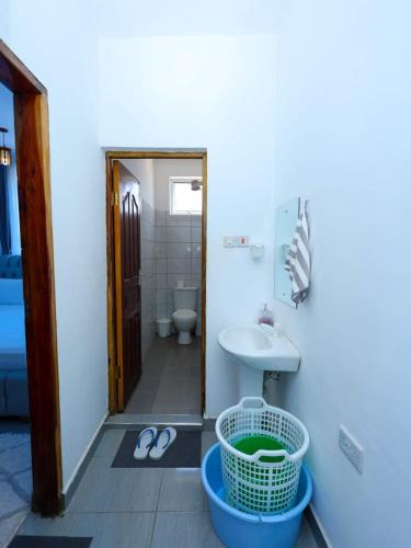 a bathroom with a sink and a toilet at Kenya coast stays in Nyali