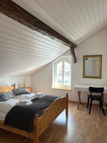 a bedroom with a bed and a desk and a window at Nimbuzzz Apartments in Unterseen