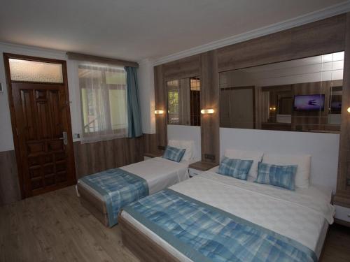 a hotel room with two beds and a mirror at Oscar Boutique Hotel in Antalya