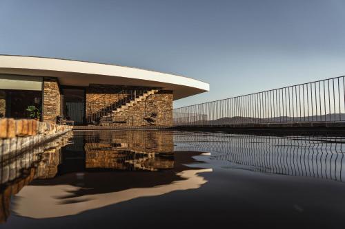 a building with its reflection in a body of water at Quinta Vale das Papas in Casal de Loivos