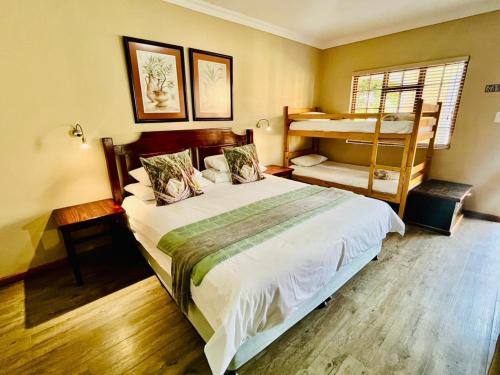 a bedroom with a large bed and a bunk bed at 17 on Bird Guest House in Beaufort West