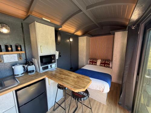 a small room with a bed and a wooden table at Lake View Retreats in Rickmansworth