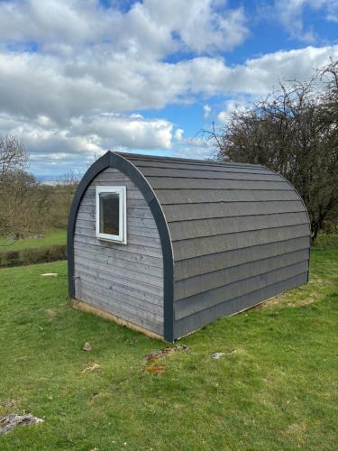a small shed with a window in a field at Hillside Pod in Oswestry