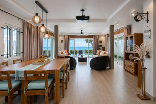 a living room with a wooden table and a dining room at The Compound - Villa 3 in Baie du Tombeau