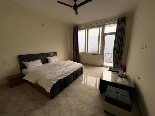 a bedroom with a bed and a large window at Hotel Suryavansham in Gupta Kāshi