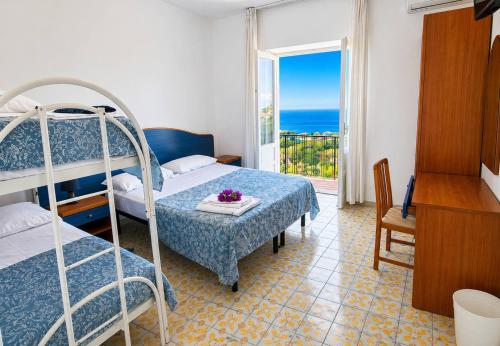 a bedroom with a bunk bed and a table with flowers on it at Hotel Bellavista in Sant'Angelo D'Ischia
