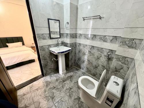 a bathroom with a sink and a toilet and a bed at Hotel Suryavansham in Gupta Kāshi
