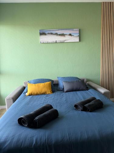 a large blue bed with three pillows on it at Studio côté soleil in Saint-Jean-de-Monts