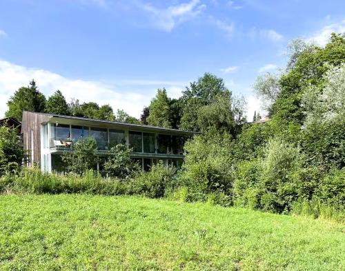 a house on a hill with a green field at Blueberry Living - Design-Apartments am Starnberger See, Natur & Erholung, Privatparkplatz, nur 400 m zum See in Tutzing