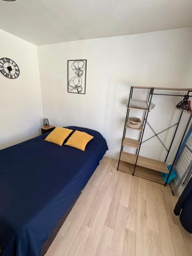 a bedroom with a bed and a ladder and a clock at Pause Confort Studio idéal centre ville in Gravelines