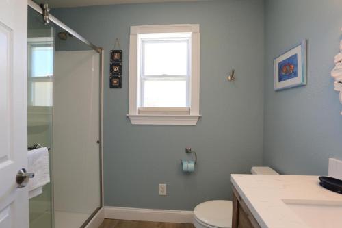 a bathroom with a shower and a toilet and a window at Buckleys Beach House by Pristine Property Vacation Rentals in Indian Pass