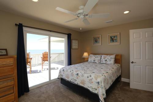 a bedroom with a bed and a door to a balcony at Buckleys Beach House by Pristine Property Vacation Rentals in Indian Pass