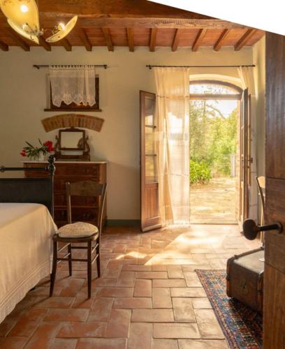 a bedroom with a bed and an open door at Il Querciolo - Azienda biologica, Agriturismo e Cantina in Marciano