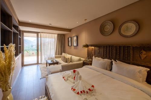 a bedroom with a large bed and a living room at La Kasbah d'Ourika - Hôtel Restaurant & Spa in Ourika