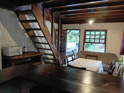 a room with a table and a spiral staircase at Apartamentos do Centrinho do Rosa in Imbituba