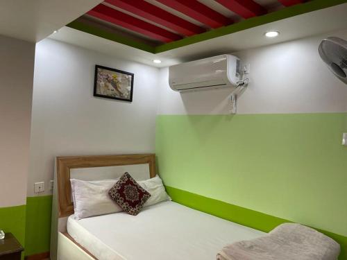 a room with a green and white wall with a bed at Hotel Best Ocean in Kathmandu