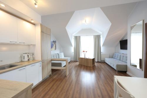 a kitchen and living room with white cabinets at Apartamenty Zdrojowa in Świnoujście