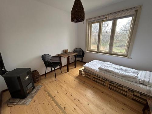 a room with a bed and a table and chairs at Privatzimmer auf Pferdehof in Vŭbel