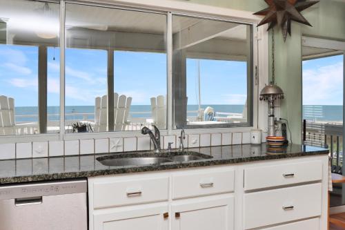 a kitchen with a view of the beach through windows at White Pelican by Pristine Property Vacation Rentals in Indian Pass