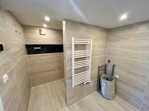 a bathroom with wooden walls and a white shelf at La Casetta in Malden
