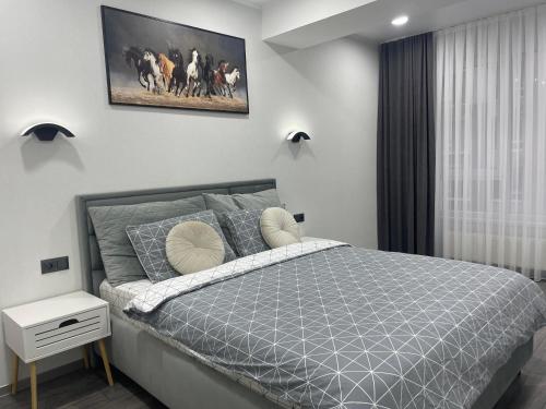 a bedroom with a bed and a picture on the wall at Modern Apartment in Chişinău