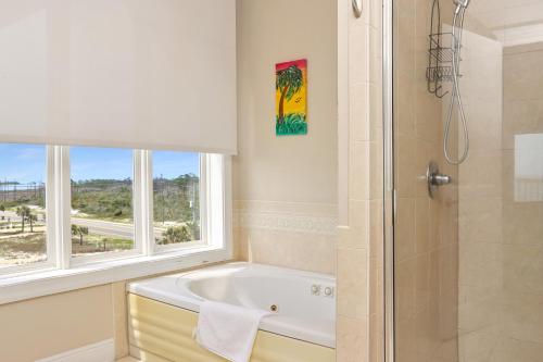 a bathroom with a tub and a shower and a window at Villa del Sol by Pristine Property Vacation Rentals in Cape San Blas