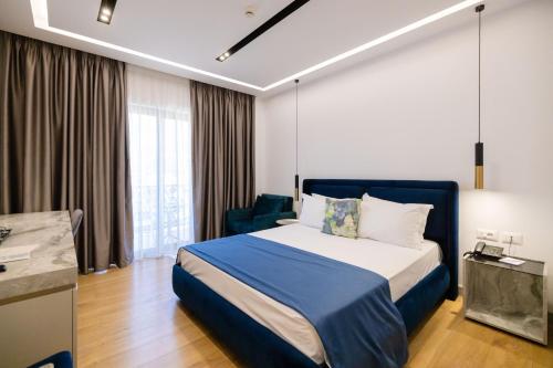 ein Hotelzimmer mit einem Bett und einem Stuhl in der Unterkunft Chimaera Hotel in Himarë