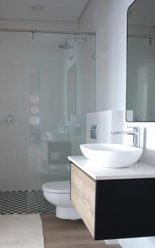 a bathroom with a sink and a toilet and a mirror at PenthouseOne on the Canals in Marina Glades