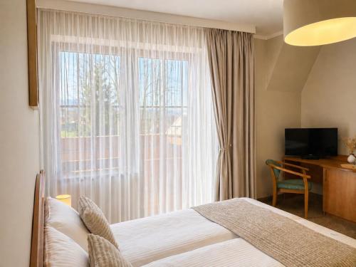 a hotel room with a bed and a large window at Willa Park in Zakopane