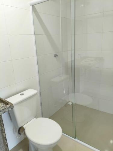 a bathroom with a toilet and a glass shower at Lazer , Descanso, Pesca e Praia in Iguape